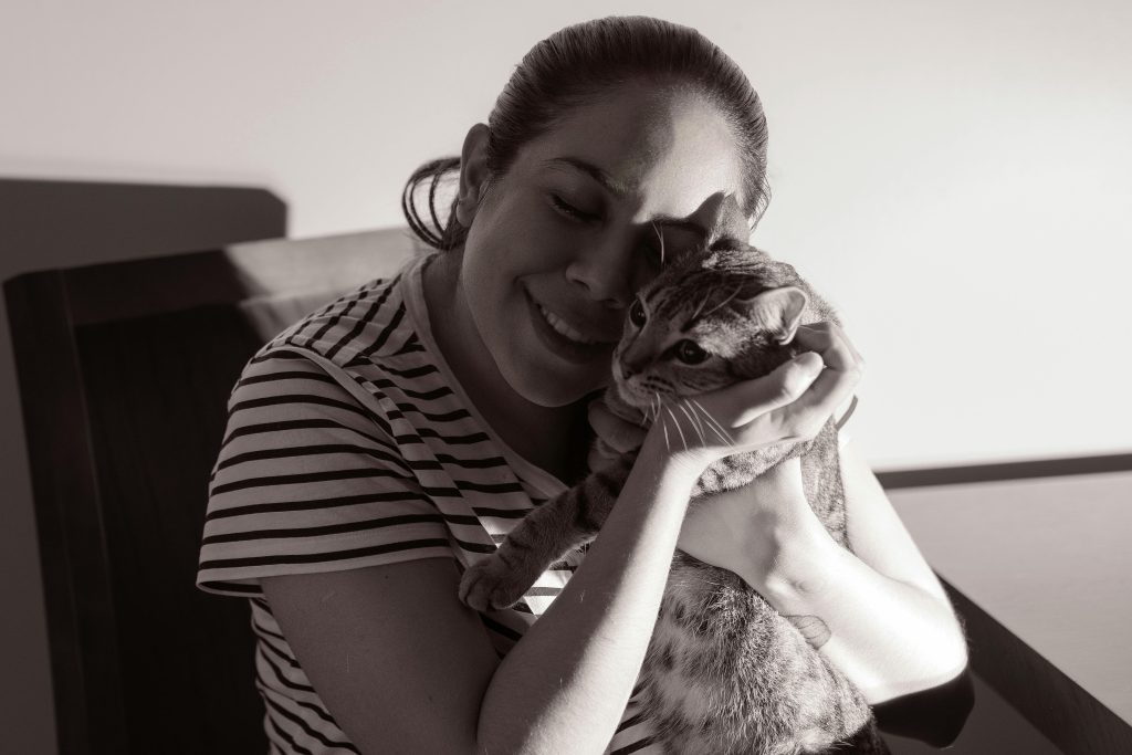 pexels-photo-29497238-29497238 A woman lovingly embraces her cat, showcasing a tender moment indoors.